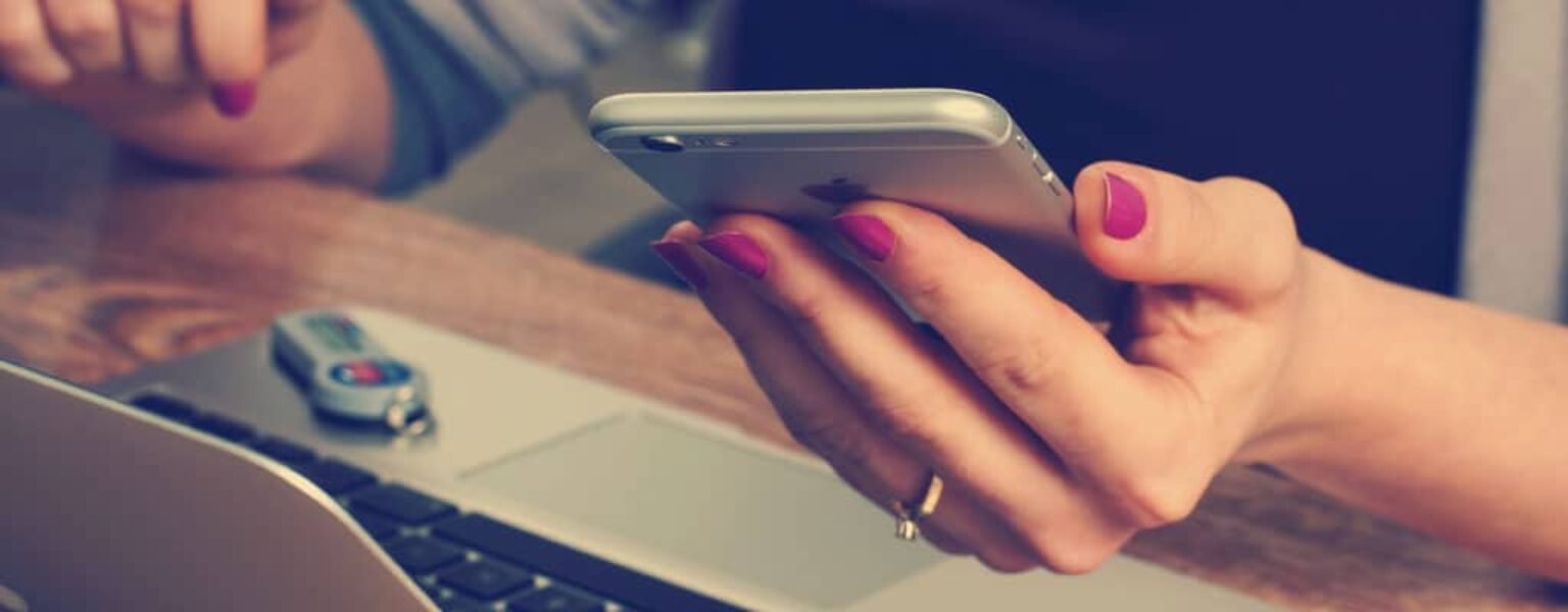 Woman logging into her computer using two factor authentication from her phone