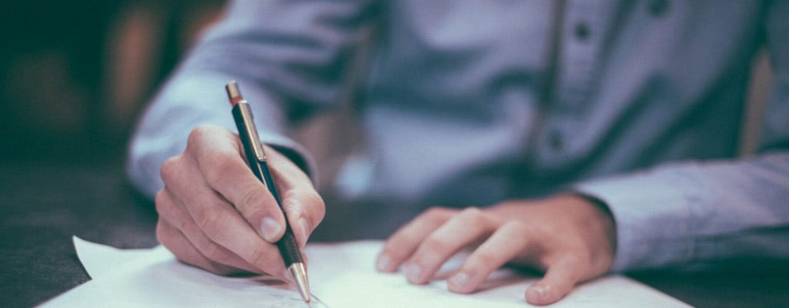 Man signing paper in law office